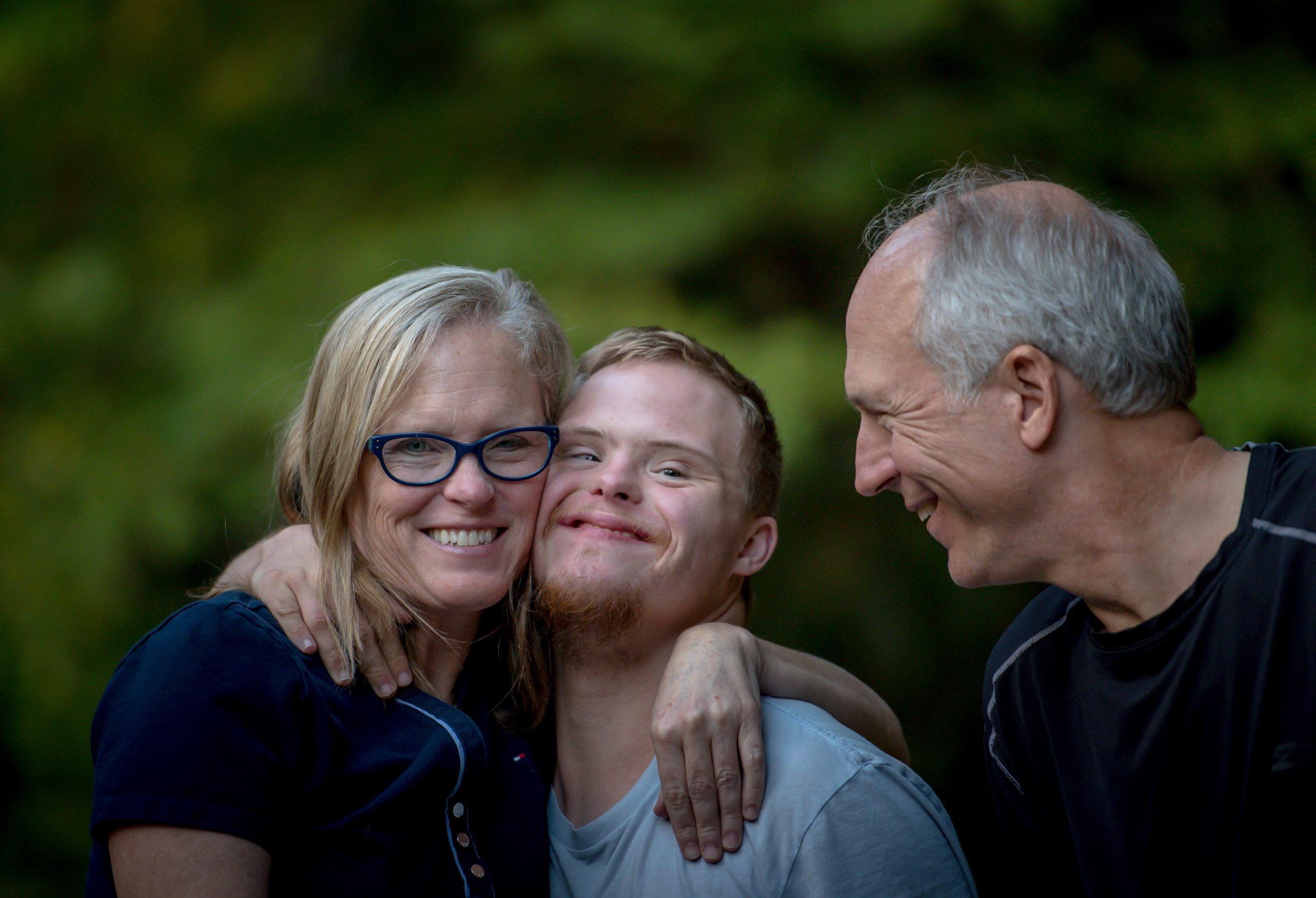 Mom and Dad with special needs son hugging